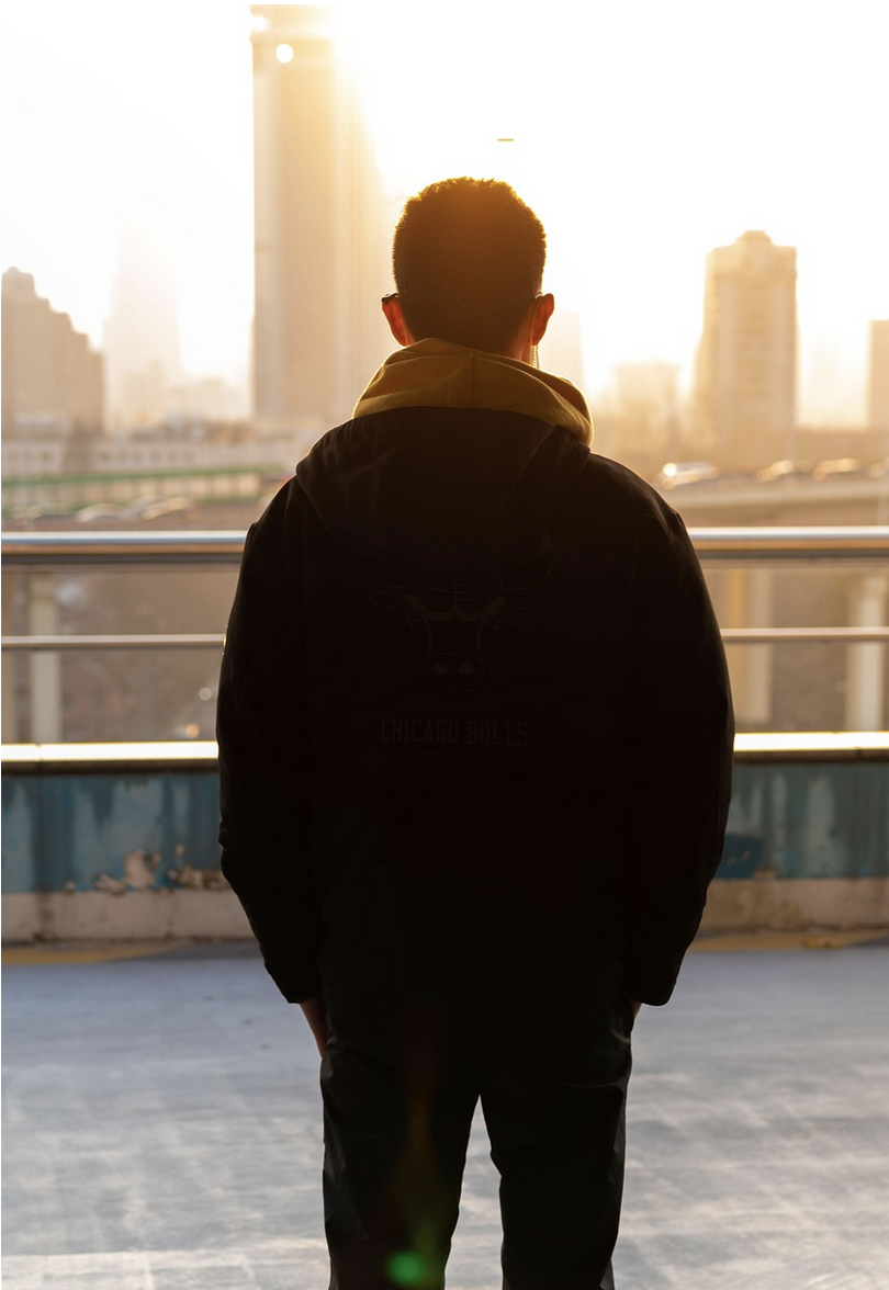 man looking at city from rooftop